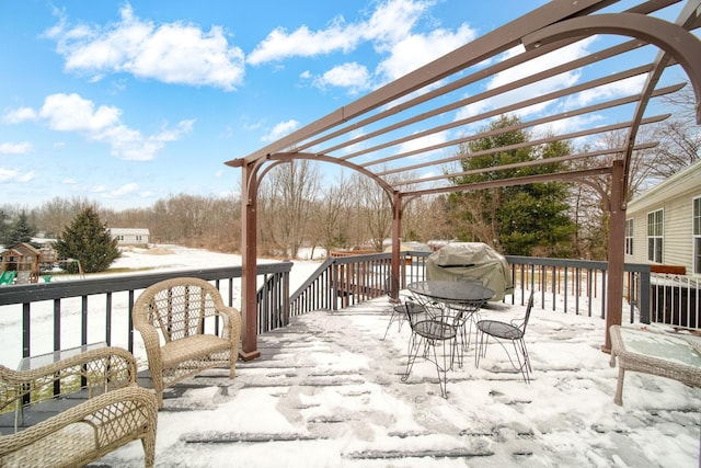 snow covered deck featuring a pergola