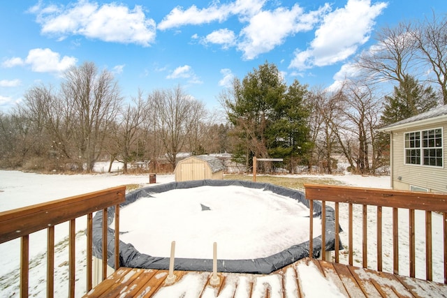 snow covered deck featuring a storage shed