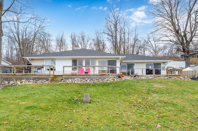 rear view of property featuring a yard, a deck, and a sunroom