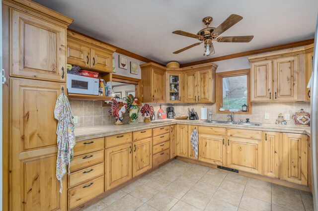 kitchen featuring light tile patterned flooring, tasteful backsplash, ceiling fan, and sink