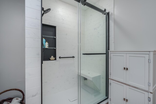 bathroom with a shower with door