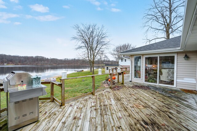 wooden deck with a water view, grilling area, and a lawn