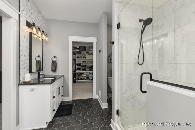 bathroom with tile patterned floors, vanity, toilet, and a shower with door