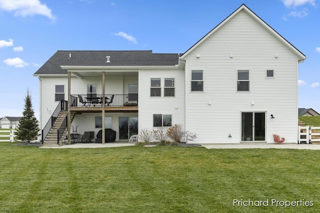 rear view of property with a lawn, a patio area, and a wooden deck