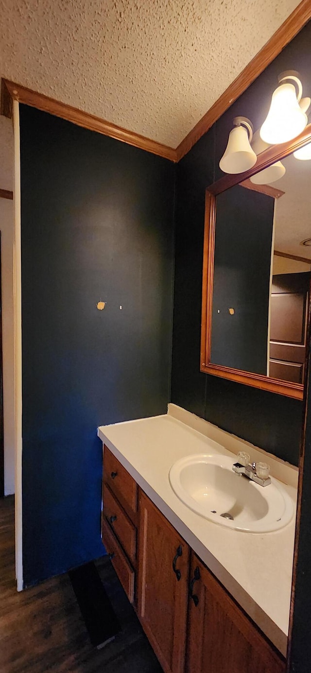 bathroom featuring hardwood / wood-style floors, vanity, and ornamental molding