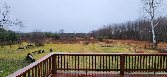 wooden deck featuring a rural view and a lawn