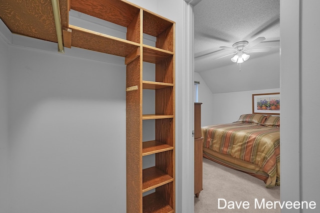 bedroom featuring ceiling fan, light colored carpet, and vaulted ceiling