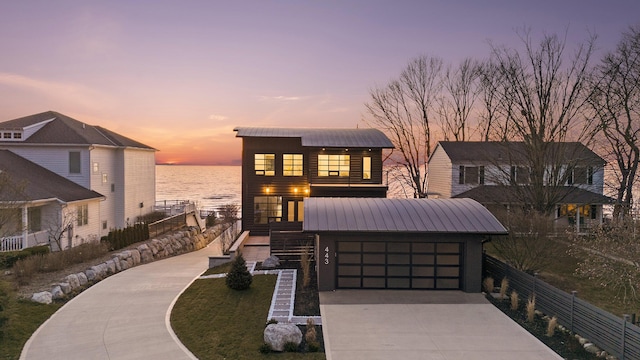 view of front of house with a garage and a water view