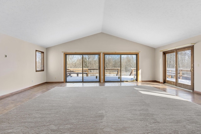 unfurnished living room with lofted ceiling, a textured ceiling, and a healthy amount of sunlight