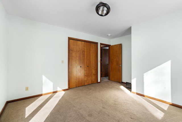 unfurnished bedroom with light carpet and a closet