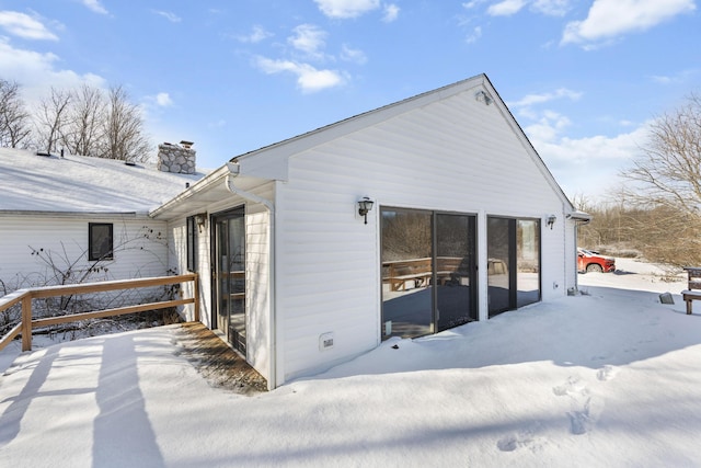 view of snow covered back of property