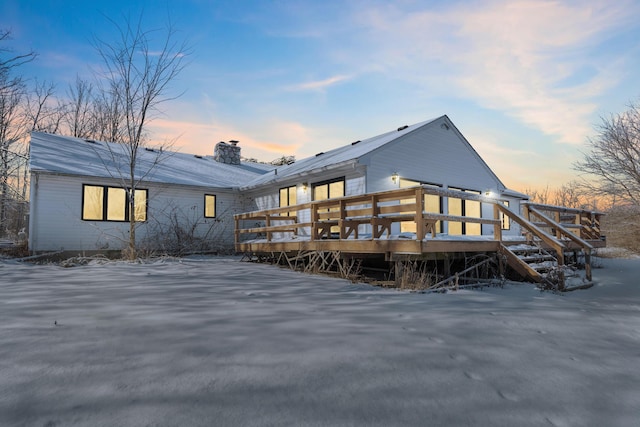 snow covered house featuring a deck