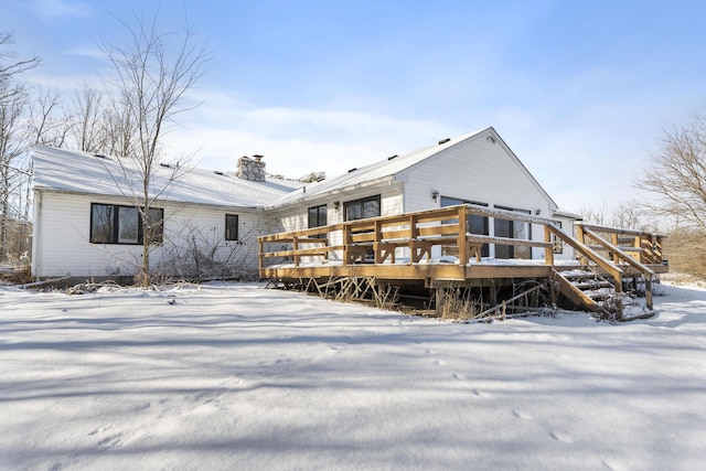 snow covered property with a deck