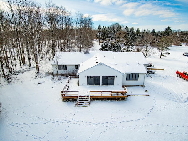 snow covered property with a wooden deck