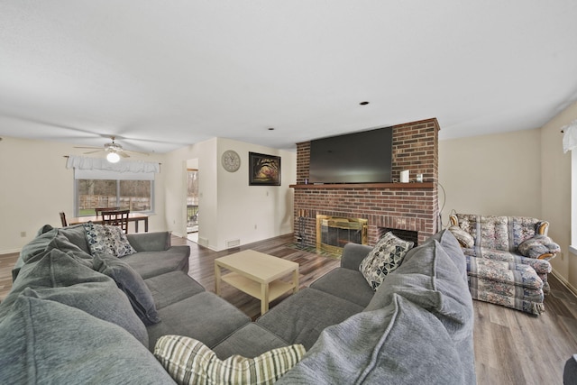 living room with a fireplace, hardwood / wood-style floors, and ceiling fan