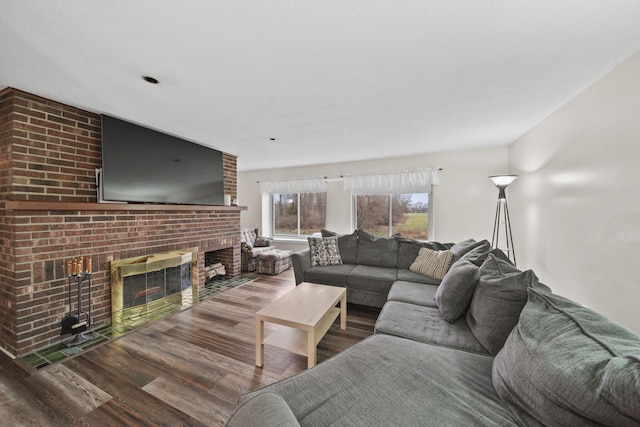 living room featuring hardwood / wood-style flooring and a brick fireplace