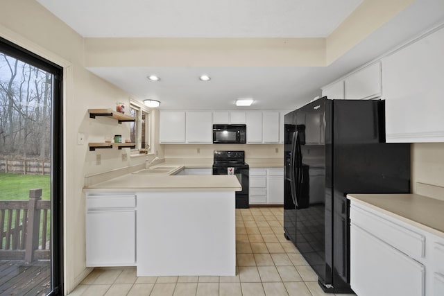 kitchen featuring black appliances, white cabinetry, sink, and light tile patterned floors