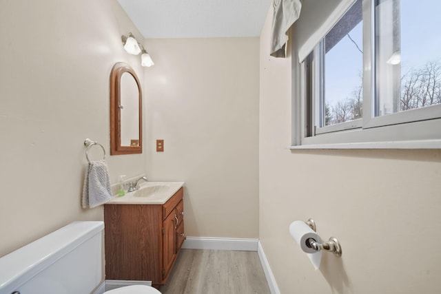 bathroom featuring vanity, hardwood / wood-style flooring, and toilet