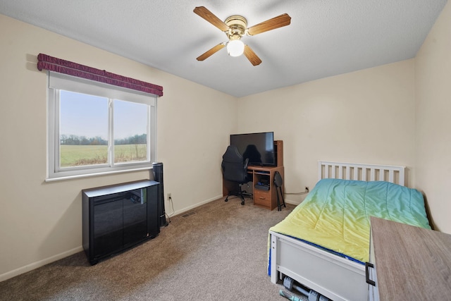 carpeted bedroom with a textured ceiling and ceiling fan