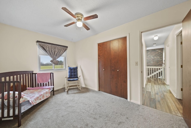 bedroom with ceiling fan, carpet floors, and a textured ceiling