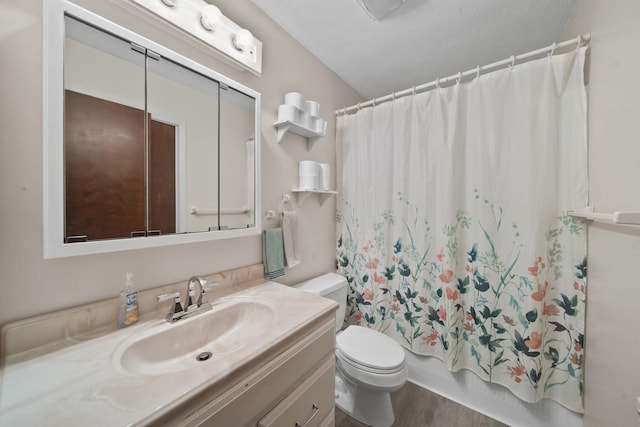 full bathroom with hardwood / wood-style floors, vanity, shower / bath combination with curtain, toilet, and a textured ceiling