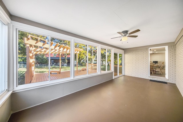 unfurnished sunroom with ceiling fan