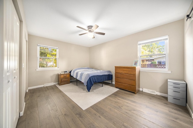 bedroom with light wood-type flooring, a closet, and ceiling fan