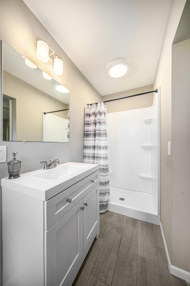 bathroom with a shower with curtain, hardwood / wood-style floors, and vanity