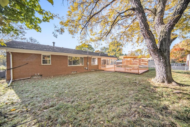 back of property featuring a deck and a yard