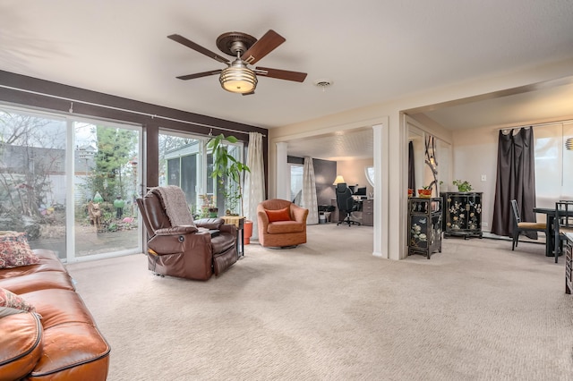 carpeted living room with ceiling fan