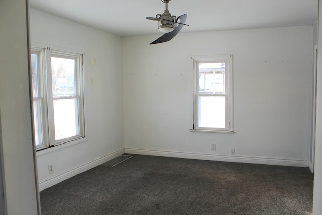 unfurnished room with ceiling fan and dark carpet