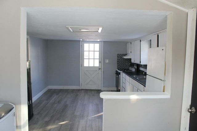 kitchen with dark hardwood / wood-style flooring, electric range, white fridge, and white cabinetry