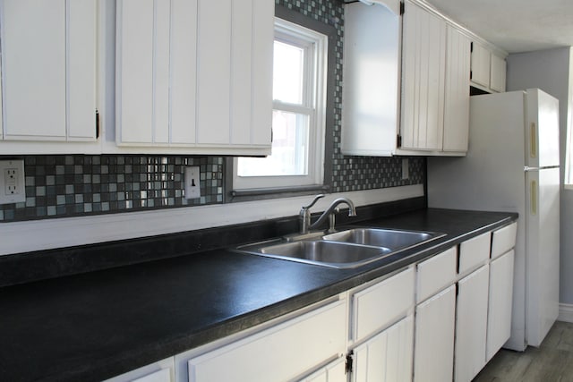 kitchen featuring backsplash, sink, and white cabinets