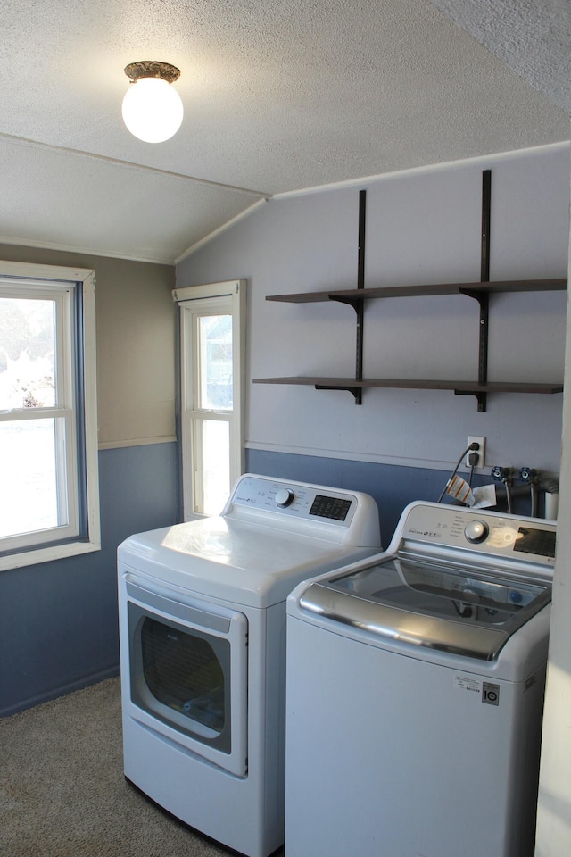 clothes washing area with carpet, separate washer and dryer, and a textured ceiling