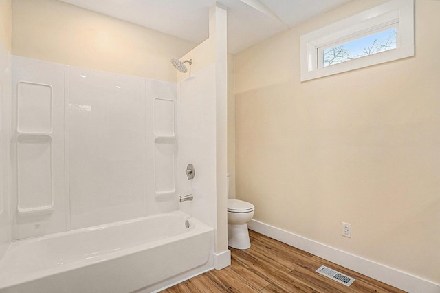 bathroom featuring hardwood / wood-style floors, shower / bath combination, and toilet