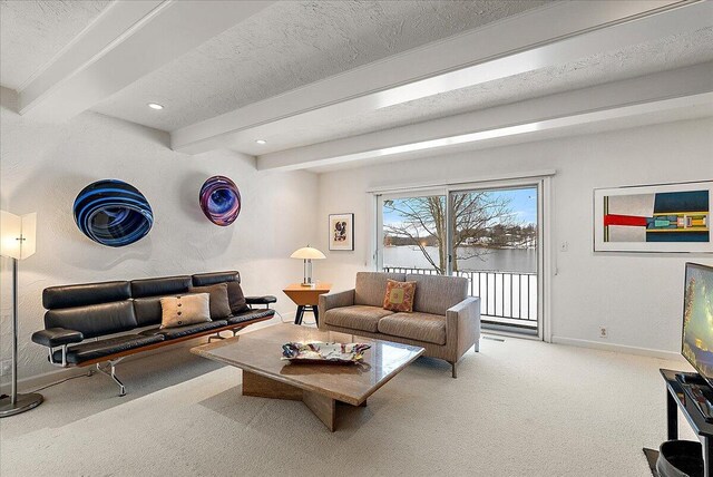 carpeted living room featuring beam ceiling