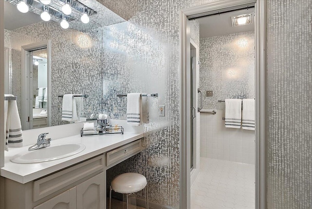 bathroom featuring vanity and a shower with door