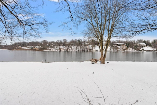 yard layered in snow featuring a water view