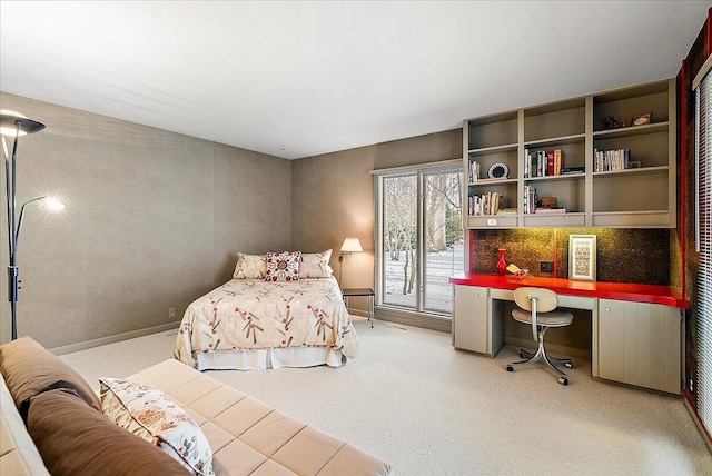 bedroom featuring access to outside, carpet floors, and built in desk