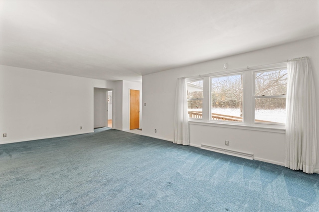 empty room featuring plenty of natural light, carpet flooring, and a baseboard heating unit