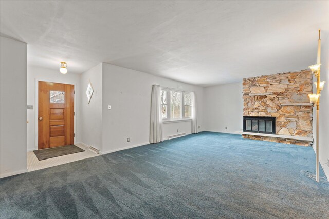 unfurnished living room with carpet flooring, a baseboard heating unit, and a fireplace