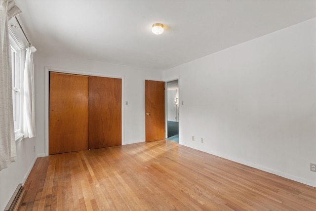 unfurnished bedroom featuring light wood-type flooring and a closet