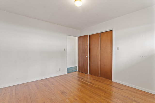 unfurnished bedroom featuring light hardwood / wood-style flooring and a closet