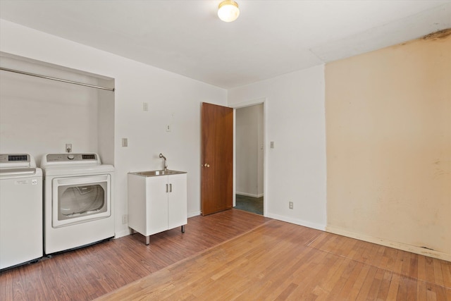 washroom featuring sink, hardwood / wood-style flooring, and separate washer and dryer