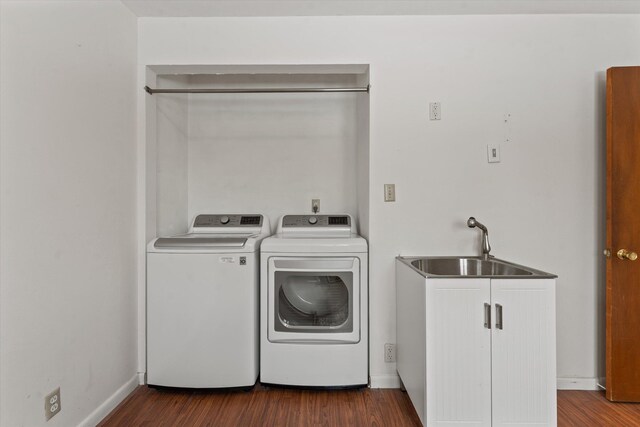 laundry area featuring sink, cabinets, washing machine and dryer, and dark hardwood / wood-style floors