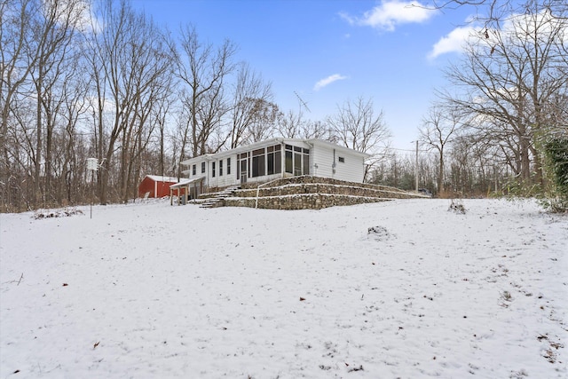 snow covered property featuring a sunroom