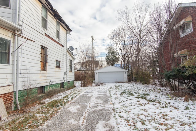 view of snow covered exterior featuring an outdoor structure and a garage