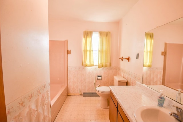 bathroom with vanity, a bathtub, toilet, and tile walls