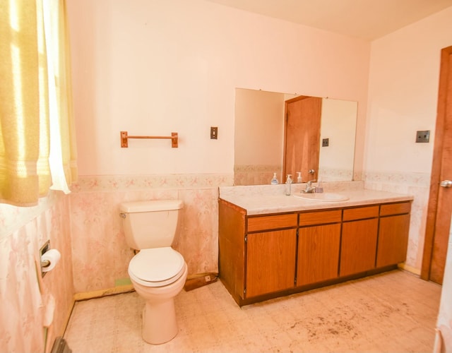 bathroom with vanity, tile walls, and toilet