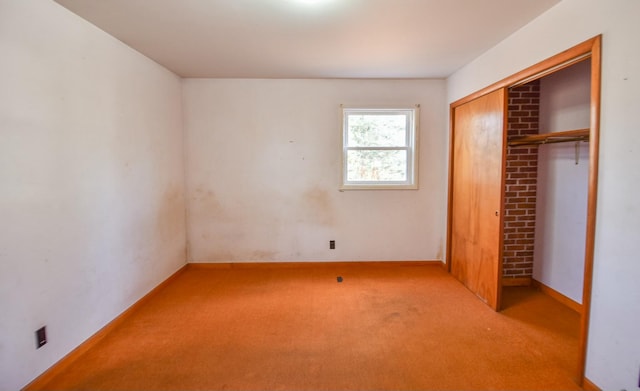 unfurnished bedroom with light colored carpet and a closet